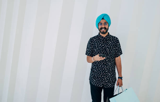 istock Portrait Of Happy Man Using A Mobile Phone While Standing In Front Of White Geometric Wall 1440805171