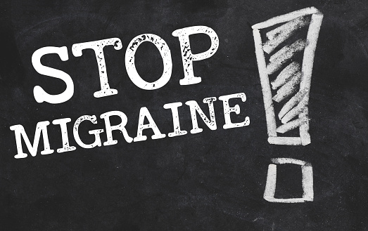 stop migraine words written in white chalk on a blackboard.