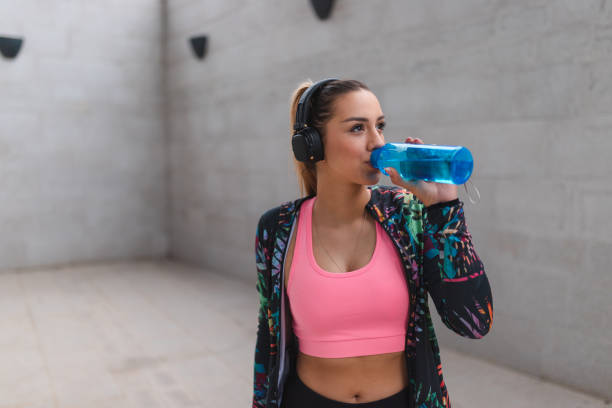 istock Fit young woman drinking water outdoors while taking a break from her workout 1440808196