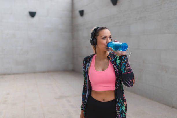 istock Fit young woman drinking water outdoors while taking a break from her workout 1440808199