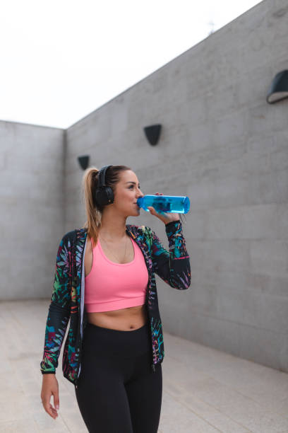 istock Fit young woman drinking water outdoors while taking a break from her workout 1440808238