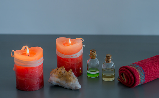 still life of candles and oils for therapies, lighted colored candles, quartz and oils for massages and therapies.