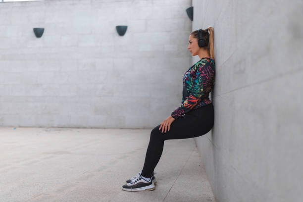 istock Young athletic woman doing the wall sit exercise outdoors 1440808374