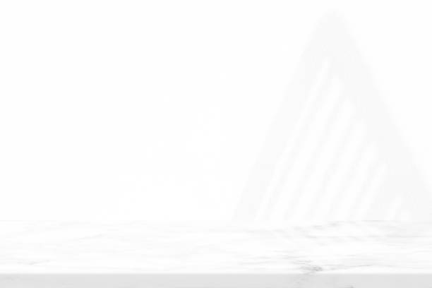 istock Marble Table with White Stucco Wall Texture Background with Light Beam and Fence Shadow, Suitable for Product Presentation Backdrop, Display, and Mock up. 1440809753
