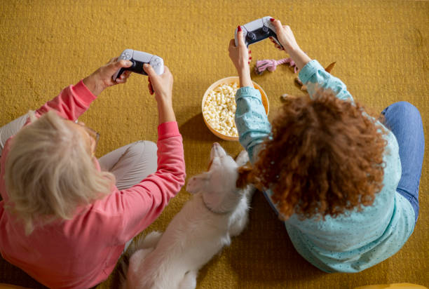 grand-mère et petite-fille passant du temps à jouer à playstation - child little girls television playstation photos et images de collection