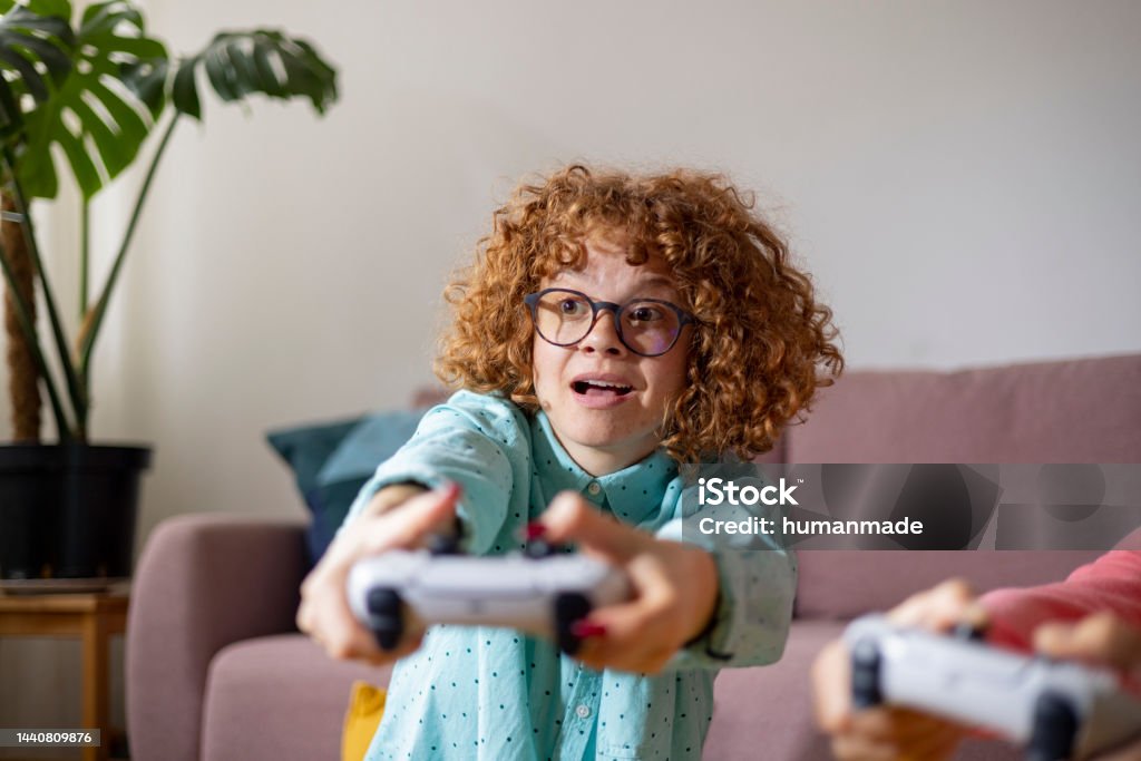 Playstation fun Ginger girl withe glasses playing playstation Television Set Stock Photo