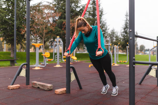 istock Athletic young woman working out outdoors by using ropes 1440810794