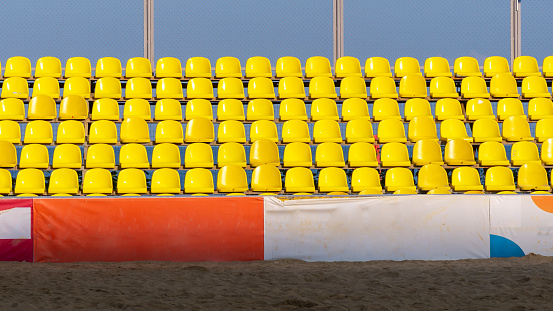 Plenty of yellow plastic seats at stadium. Sport