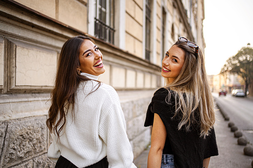 Two young and beautiful female friends walking through the city