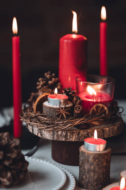 istock Rustic table decor for Christmas or New Year family dinner. Centrepiece with red candle, dry orange, cone, cinnamon, anise. Zero waste eco-friendly home. Cozy atmosphere, dark background. Close up 1440814851