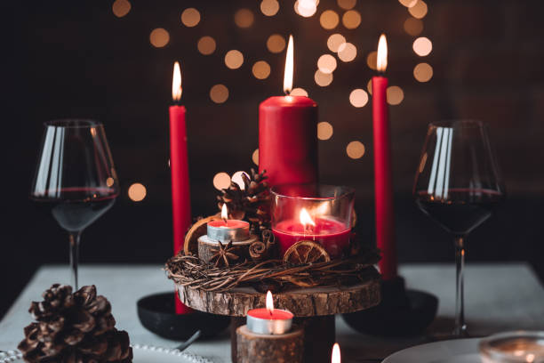 istock Rustic table decor for Christmas or New Year family dinner. Centrepiece with red candle, dry orange, cone, cinnamon, anise. Zero waste eco-friendly home. Cozy atmosphere, dark background. Close up 1440814981