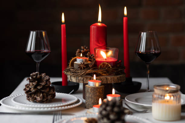 istock Rustic table decor for Christmas or New Year family dinner. Centrepiece with red candle, dry orange, cone, cinnamon, anise. Zero waste eco-friendly home. Cozy atmosphere, dark background. Close up 1440814984