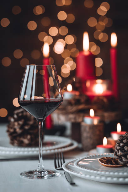 istock Rustic table decor for Christmas or New Year family dinner. Centrepiece with red candle, dry orange, cone, cinnamon, anise. Zero waste eco-friendly home. Cozy atmosphere, dark background. Close up 1440815031