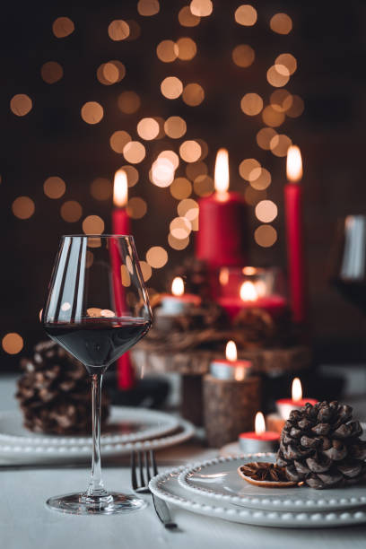 istock Rustic table decor for Christmas or New Year family dinner. Centrepiece with red candle, dry orange, cone, cinnamon, anise. Zero waste eco-friendly home. Cozy atmosphere, dark background. Close up 1440815111