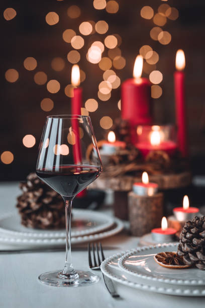 istock Rustic table decor for Christmas or New Year family dinner. Centrepiece with red candle, dry orange, cone, cinnamon, anise. Zero waste eco-friendly home. Cozy atmosphere, dark background. Close up 1440815186