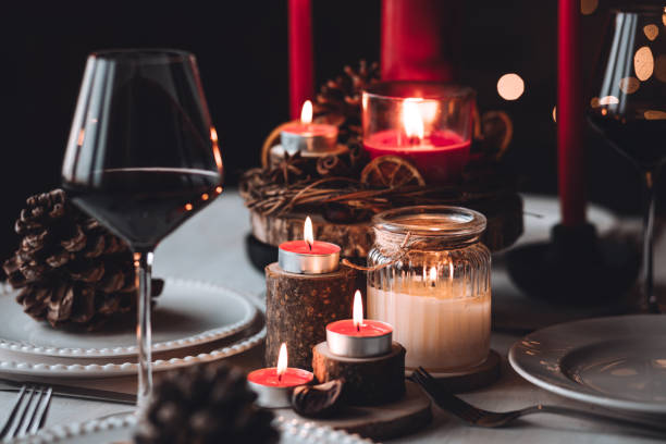 istock Rustic table decor for Christmas or New Year family dinner. Centrepiece with red candle, dry orange, cone, cinnamon, anise. Zero waste eco-friendly home. Cozy atmosphere, dark background. Close up 1440815510