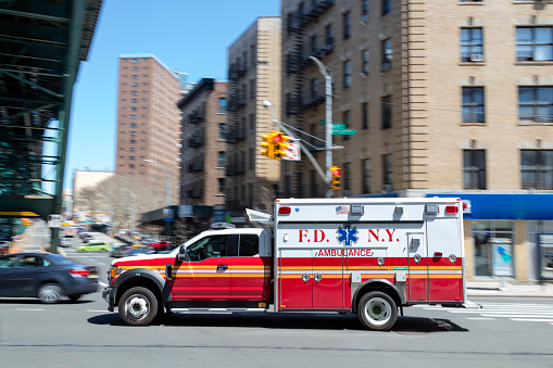 Motion blurred ambulance speeding down street in New York City, USA.