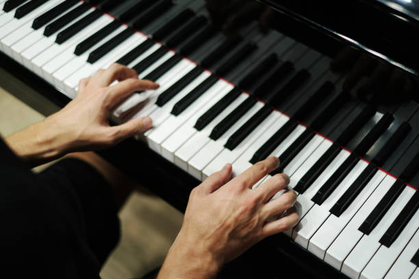 mani di un uomo che suona il pianoforte primo piano - piano piano key orchestra close up foto e immagini stock