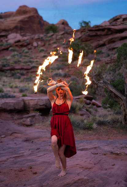 istock Young woman dancing with fire in the desert 1440823784
