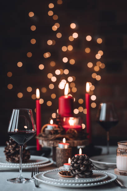 istock Rustic table decor for Christmas or New Year family dinner. Centrepiece with red candle, dry orange, cone, cinnamon, anise. Zero waste eco-friendly home. Cozy atmosphere, dark background. Close up 1440825418