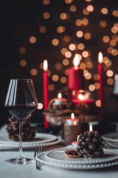 istock Rustic table decor for Christmas or New Year family dinner. Centrepiece with red candle, dry orange, cone, cinnamon, anise. Zero waste eco-friendly home. Cozy atmosphere, dark background. Close up 1440825423