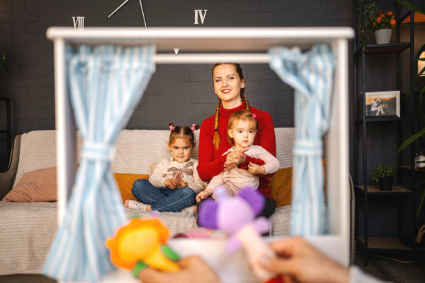 istock Loving father performing puppet show at home for his little daughters 1440825743
