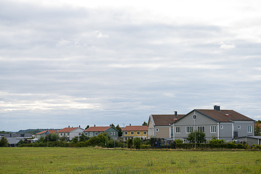 Row of residential houses by a green field.