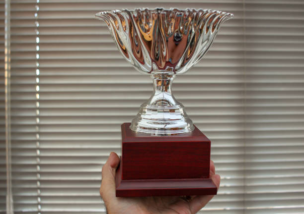 istock winner with a cup in his hand 1440829560