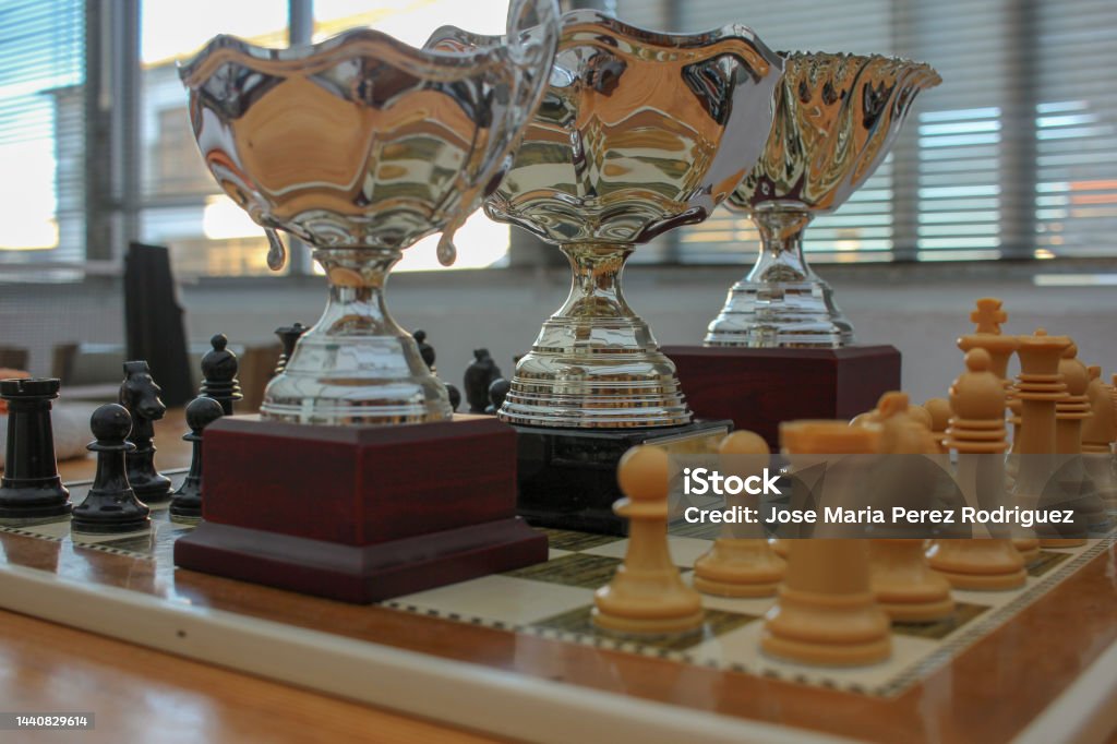 a good strategy on the chessboard lets you achieve the trophies a good strategy is instrumental in achieving rewards Achievement Stock Photo