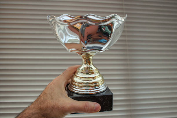 istock holding the cup of the champion 1440829618
