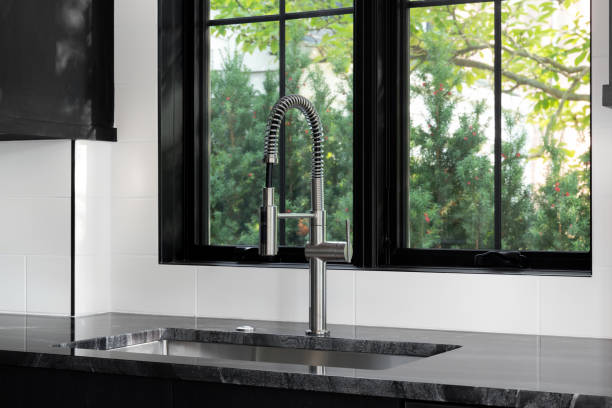 istock A kitchen sink in a kitchen with black cabinets and white tile backsplash. 1440832393