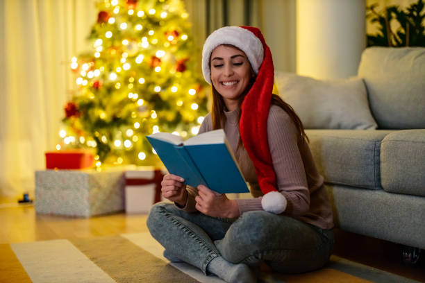 istock Girl reading next to a Christmas tree 1440832659