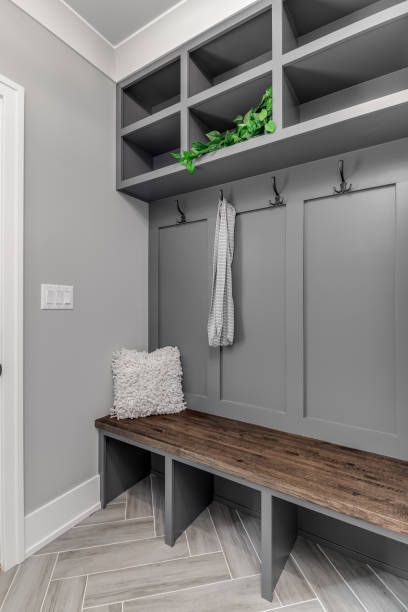 istock A mudroom with a grey built-in with shelving and a wooden bench. 1440832662