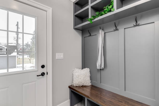 istock A mudroom with a grey built-in with shelving and a wooden bench. 1440832668