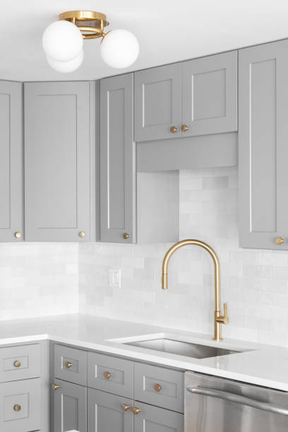 istock A gold faucet in a grey and white kitchen. 1440834371