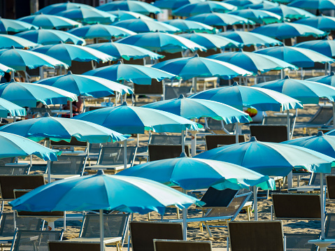 Blue sun umbrellas on the beach in Rimini, Italy