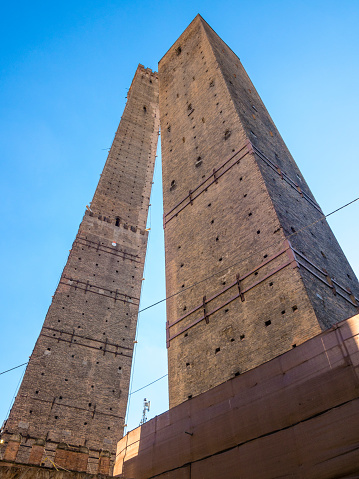 The Two Towers (Le due torri), both of them leaning, are the symbol of Bologna, Italy, and the most prominent of the Towers of Bologna. They are located at the intersection of the roads that lead to the five gates of the old ring wall. The taller one is called the Asinelli, while the smaller tower is called the Garisenda.