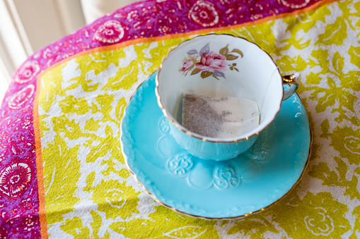 Empty vintage blue teacup and saucer with a teabag
