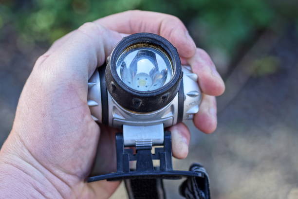 istock hand holding one gray black plastic led headlamp 1440844112