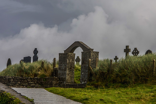 Wide angle view of a cemetery and church ruin in County Kerry, Ireland. Taken late in the evening just before sunset. Space for copy at top of image.