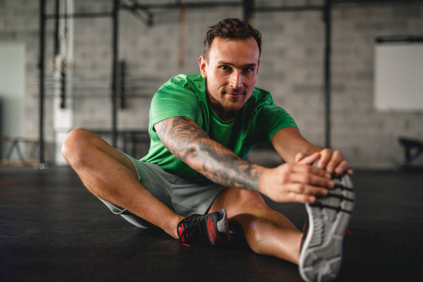 istock Confident Young Male Athlete Stretching at Gym 1440866934