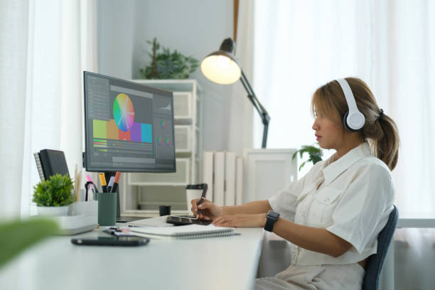 istock Side view of young creative female editing artwork, using graphics tablet and a stylus pen, working new project in home office. 1440866974