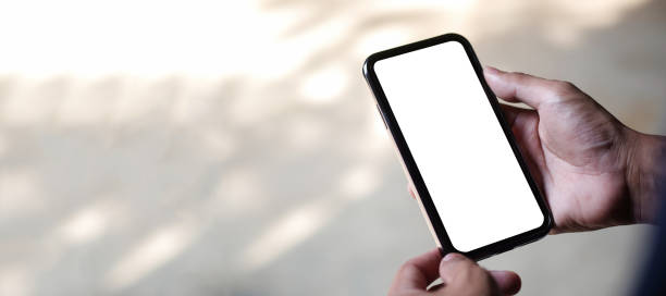istock Young man holding mockup smart phone with white empty screen. 1440867282