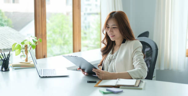 istock Successful entrepreneur using laptop and working with accounting document at bright modern office. 1440868092