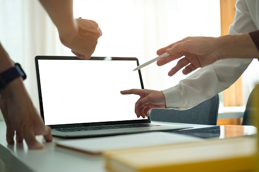 Cropped image of businesspeople hands pointing on laptop screen. Blank screen for your advertise tex.