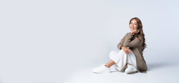 istock Website header.Elegant young woman in a brown jacket posing on white background. 1440868457