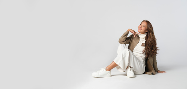 Panoramic photo of beautiful elegant young woman in brown jacket posing on white background. Studio Shot.