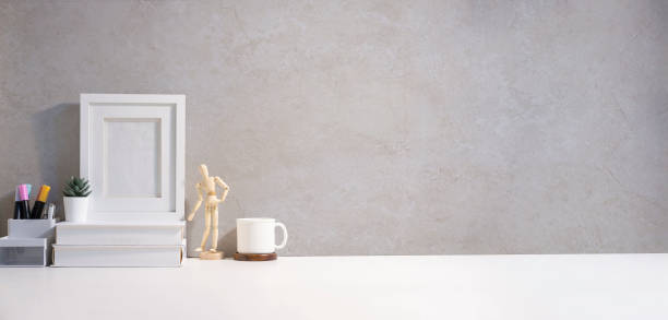 istock Minimal workplace with blank picture frame, books, coffee cup and cactus. Copy space for your text. 1440868494