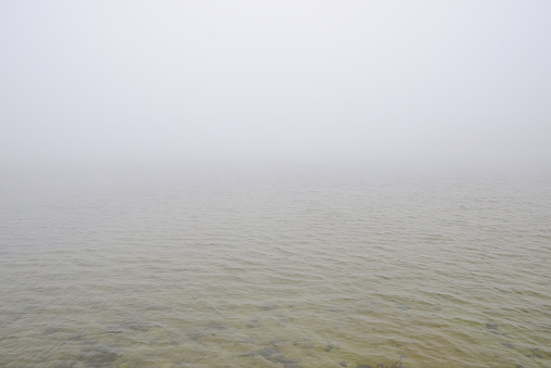 Fog on the water. Sea or lake in fog. Foggy weather. Calm beautiful relaxing misty landscape with water waves