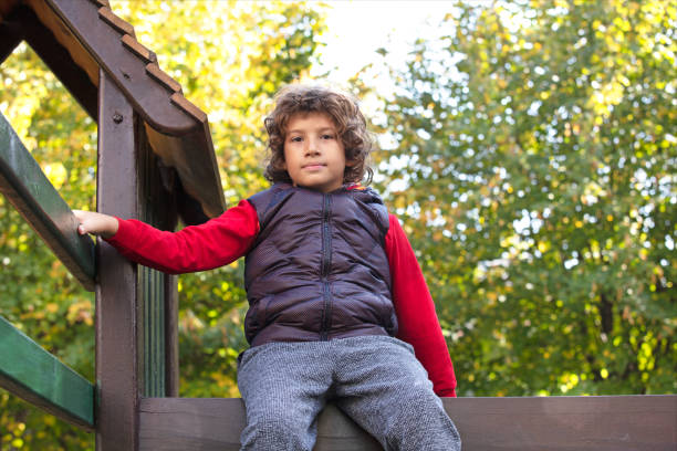 istock boy sitting on wooden stairs 1440890743